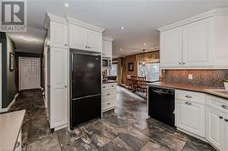 Kitchen featuring backsplash, pendant lighting, white cabinets, and black appliances - 