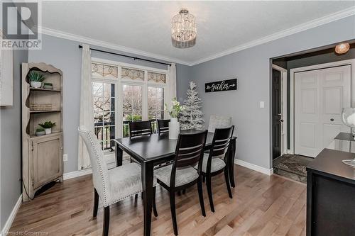 Dining space with a textured ceiling, a notable chandelier, light hardwood / wood-style floors, and crown molding - 17 Weir Drive, Guelph, ON - Indoor Photo Showing Dining Room