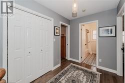 Corridor with a textured ceiling and dark hardwood / wood-style floors - 