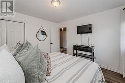 Bedroom with dark hardwood / wood-style floors and a closet - 