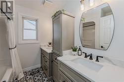 Bathroom featuring tile patterned flooring, vanity, and shower / tub combo with curtain - 