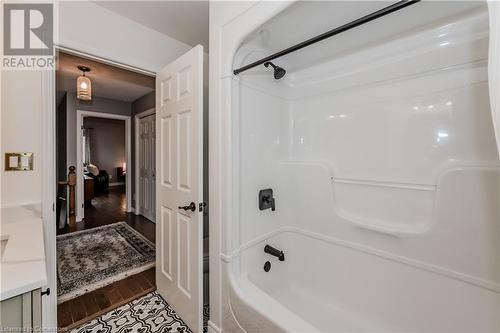 Bathroom featuring hardwood / wood-style floors and shower / washtub combination - 17 Weir Drive, Guelph, ON - Indoor Photo Showing Bathroom