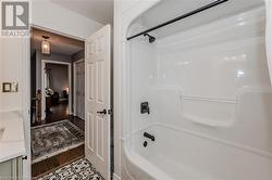 Bathroom featuring hardwood / wood-style floors and shower / washtub combination - 