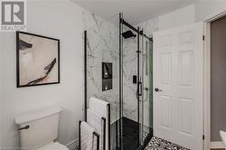 Bathroom with toilet and a shower with shower door - 