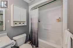 Full bathroom with shower / bathtub combination with curtain, vanity, and toilet - 