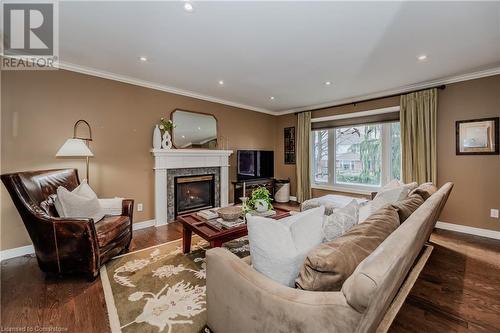 Living room featuring dark hardwood / wood-style flooring and ornamental molding - 17 Weir Drive, Guelph, ON - Indoor Photo Showing Living Room With Fireplace