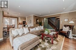 Living room with a chandelier, ornamental molding, and hardwood / wood-style flooring - 