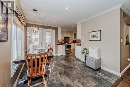 Dining space featuring french doors, a notable chandelier, and ornamental molding - 17 Weir Drive, Guelph, ON - Indoor Photo Showing Dining Room