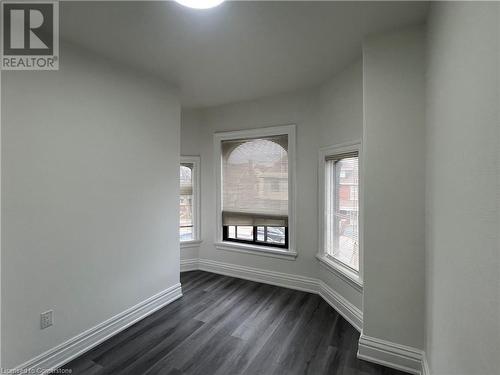 Empty room featuring dark hardwood / wood-style flooring and plenty of natural light - 660 Main Street E Unit# 1, Hamilton, ON - Indoor Photo Showing Other Room