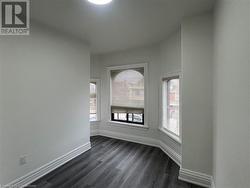 Empty room featuring dark hardwood / wood-style flooring and plenty of natural light - 