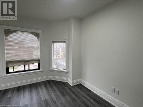 Unfurnished room featuring a healthy amount of sunlight and dark hardwood / wood-style flooring - 660 Main Street E Unit# 1, Hamilton, ON - Indoor Photo Showing Other Room