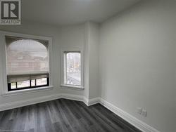 Unfurnished room featuring a healthy amount of sunlight and dark hardwood / wood-style flooring - 