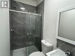 Bathroom with toilet, an enclosed shower, and sink - 