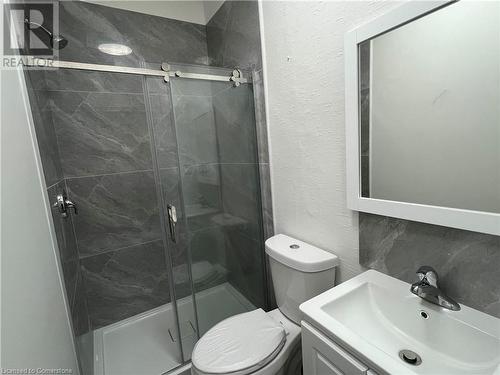 Bathroom featuring decorative backsplash, vanity, an enclosed shower, and toilet - 660 Main Street E Unit# 1, Hamilton, ON - Indoor Photo Showing Bathroom