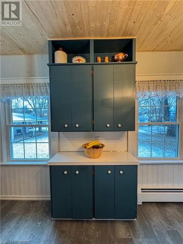 Kitchen with wood walls, wooden ceiling, dark hardwood / wood-style floors, and a baseboard heating unit - 166 North Street, Fort Erie, ON - Indoor