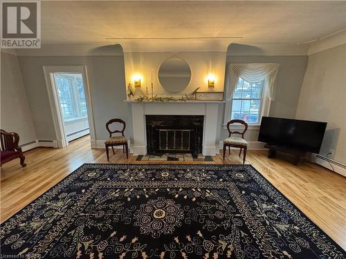 Living area with wood-type flooring and a baseboard heating unit - 166 North Street, Fort Erie, ON - Indoor Photo Showing Living Room With Fireplace