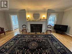 Living area with wood-type flooring and a baseboard heating unit - 