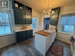 Kitchen featuring wood counters, plenty of natural light, hanging light fixtures, and an inviting chandelier - 