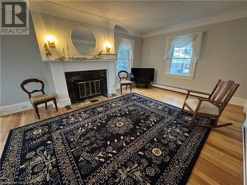 Living area with hardwood / wood-style floors, a baseboard radiator, and ornamental molding - 166 North Street, Fort Erie, ON - Indoor Photo Showing Living Room With Fireplace