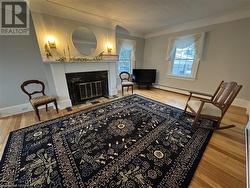 Living area with hardwood / wood-style floors, a baseboard radiator, and ornamental molding - 