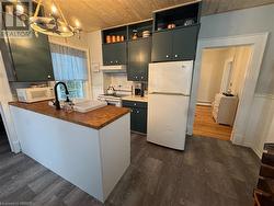 Kitchen featuring wood counters, white appliances, dark wood-type flooring, pendant lighting, and wooden ceiling - 