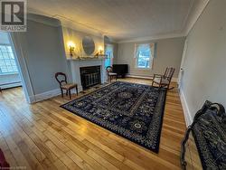 Living room featuring hardwood / wood-style floors, baseboard heating, and crown molding - 