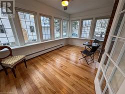 Sunroom with ceiling fan, a wealth of natural light, and a baseboard heating unit - 