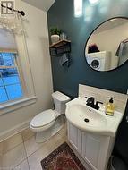 Bathroom with washer / dryer, tile patterned flooring, vanity, and toilet - 