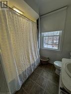 Bathroom featuring tile patterned flooring, a shower with curtain, and toilet - 