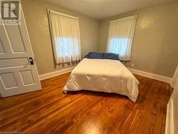 Bedroom with dark hardwood / wood-style flooring - 