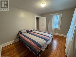 Bedroom with dark hardwood / wood-style flooring - 