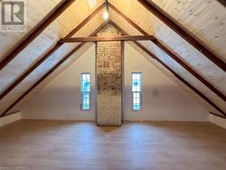 Additional living space featuring high vaulted ceiling, beamed ceiling, wooden ceiling, and hardwood / wood-style flooring - 