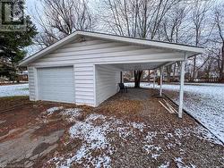 Snow covered garage with a carport - 