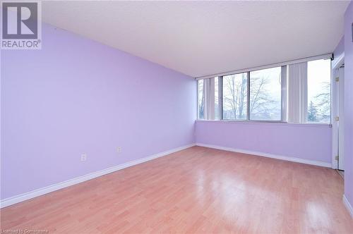 Unfurnished room featuring a textured ceiling and light wood-type flooring - 305 Webb Drive Unit# 308, Mississauga, ON 