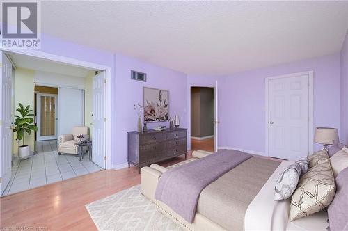 Bedroom with a textured ceiling and light wood-type flooring - 305 Webb Drive Unit# 308, Mississauga, ON 