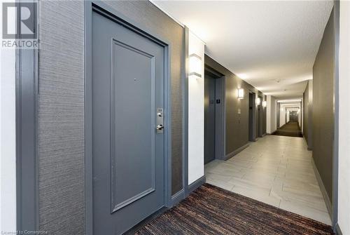 Hallway featuring elevator and a textured ceiling - 305 Webb Drive Unit# 308, Mississauga, ON 