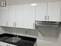 Kitchen featuring white cabinetry - 