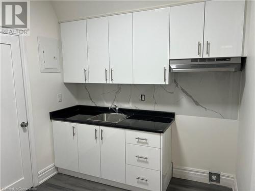 Kitchen featuring white cabinets, dark hardwood / wood-style floors, sink, and electric panel - 660 Main Street E Unit# 2, Hamilton, ON - Indoor Photo Showing Kitchen