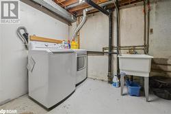 Washroom featuring washing machine and dryer and sink - 