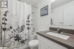 Full bathroom with vanity, toilet, and shower / bath combo with shower curtain - 