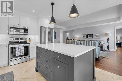 Kitchen with white cabinetry, pendant lighting, decorative backsplash, light tile patterned floors, and appliances with stainless steel finishes - 46 Halliday Drive Drive, Tavistock, ON - Indoor Photo Showing Kitchen