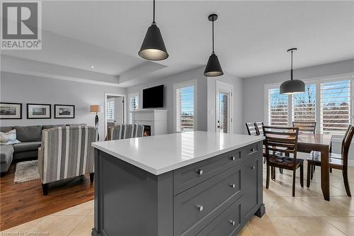 Kitchen with light wood-type flooring, gray cabinets, a kitchen island, and hanging light fixtures - 46 Halliday Drive Drive, Tavistock, ON - Indoor Photo Showing Other Room