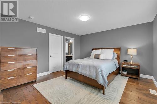 Bedroom featuring dark hardwood / wood-style flooring and ensuite bathroom - 46 Halliday Drive Drive, Tavistock, ON - Indoor Photo Showing Bedroom