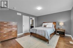 Bedroom featuring dark hardwood / wood-style flooring and ensuite bathroom - 