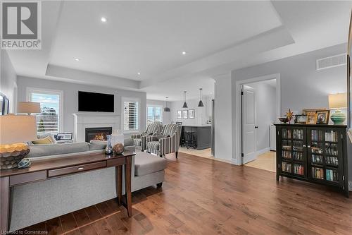 Living room featuring hardwood / wood-style flooring and a tray ceiling - 46 Halliday Drive Drive, Tavistock, ON - Indoor Photo Showing Living Room With Fireplace