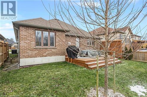 Rear view of house with a lawn, a wooden deck, and central air condition unit - 46 Halliday Drive Drive, Tavistock, ON - Outdoor