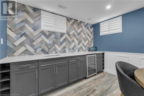 Kitchen featuring gray cabinets, light hardwood / wood-style floors, sink, and wine cooler - 46 Halliday Drive Drive, Tavistock, ON - Indoor