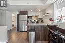 Kitchen featuring sink, white cabinetry, appliances with stainless steel finishes, light hardwood / wood-style floors, and dark brown cabinetry - 1141 Cooke Boulevard Unit# 416, Burlington, ON  - Indoor Photo Showing Kitchen 