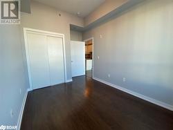 Unfurnished bedroom featuring dark wood-type flooring and a closet - 