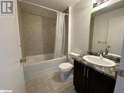 Full bathroom featuring tile patterned floors, shower / bath combination with curtain, toilet, and vanity - 